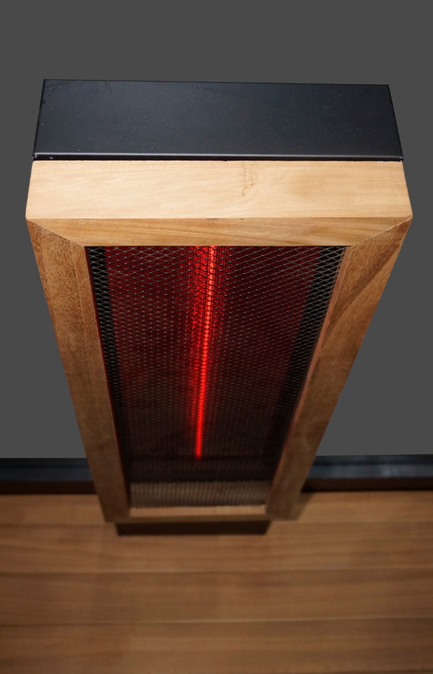 Overhead view of a rectangular infrared heater with a wooden frame, black metal grate, and visible red heating element, mounted above a wooden floor.