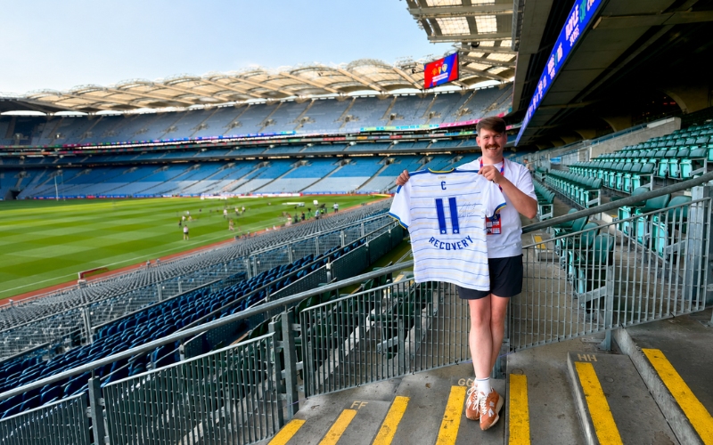 Holding up a signed Leeds United jersey with the number 11 and RECOVERY on the back on the stadium steps at Croke Park.